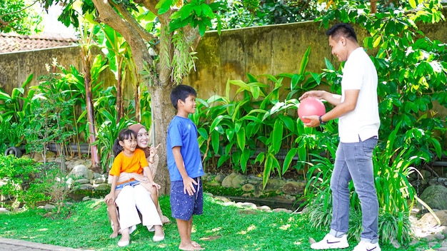 Familia feliz jugando juntos en el jardín