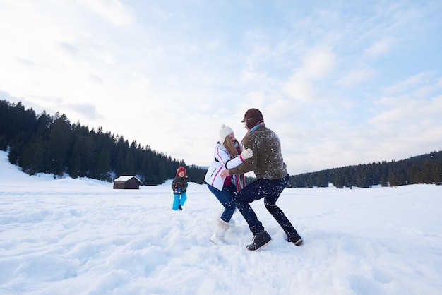 familia feliz jugando juntos en la nieve en invierno