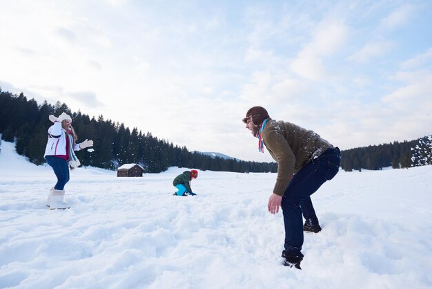 familia feliz jugando juntos en la nieve en invierno