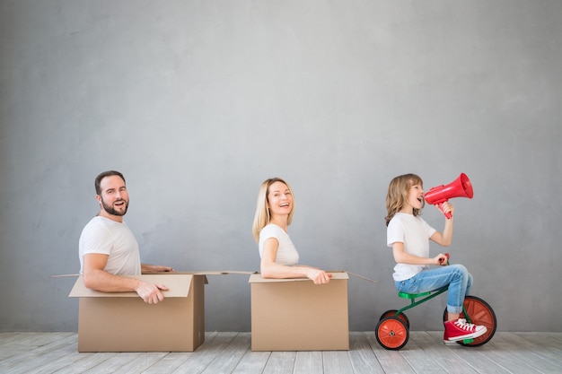 familia feliz jugando en el nuevo hogar padre madre e hijo divirtiéndose juntos día de la mudanza