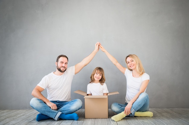 familia feliz jugando en el nuevo hogar padre madre e hijo divirtiéndose juntos día de la mudanza