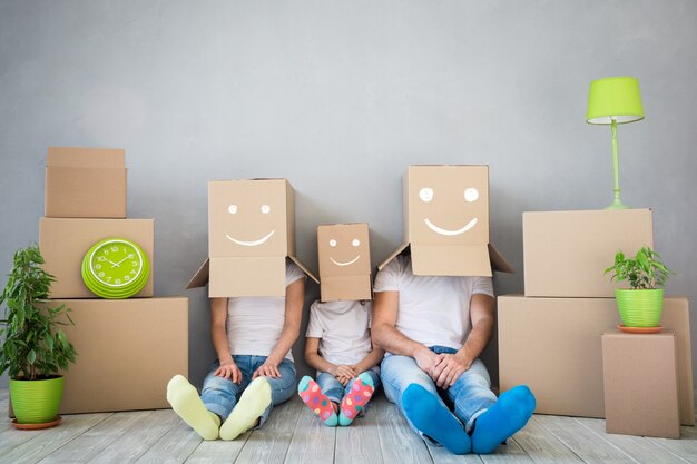 familia feliz jugando en el nuevo hogar padre madre e hijo divirtiéndose juntos día de la mudanza