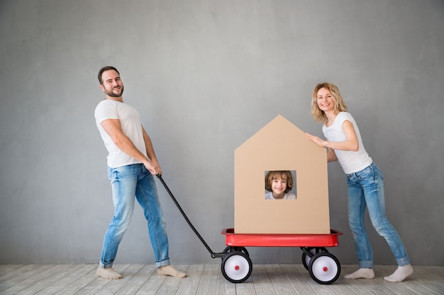 Foto familia feliz jugando en el nuevo hogar padre madre e hijo divirtiéndose juntos día de la mudanza