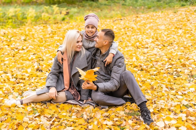 Familia feliz jugando en el parque de otoño