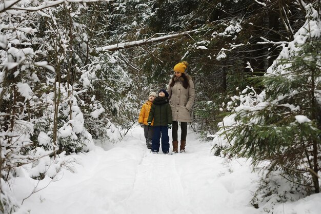 Familia feliz jugando y riendo en invierno al aire libre en el día de invierno del parque de la ciudad de nieve