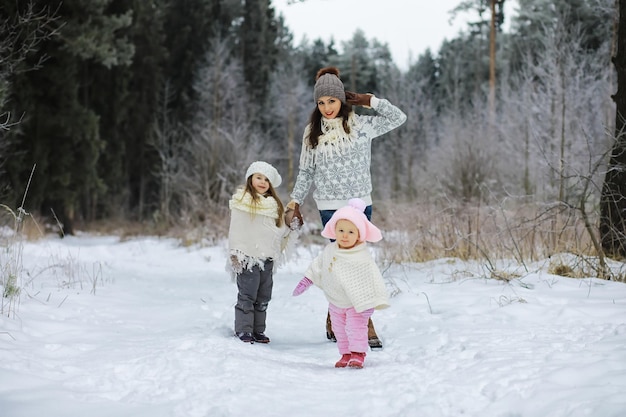 Familia feliz jugando y riendo en invierno al aire libre en la nieve. Día de invierno del parque de la ciudad.