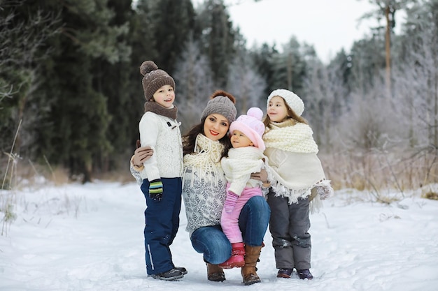 Familia feliz jugando y riendo en invierno al aire libre en la nieve. Parque de la ciudad día de invierno.