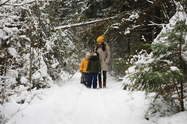 Familia feliz jugando y riendo en invierno al aire libre en la nieve. Parque de la ciudad día de invierno.