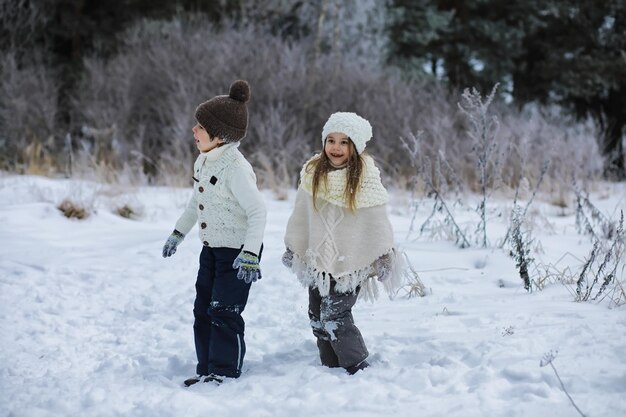 Familia feliz jugando y riendo en invierno al aire libre en la nieve. Parque de la ciudad día de invierno.