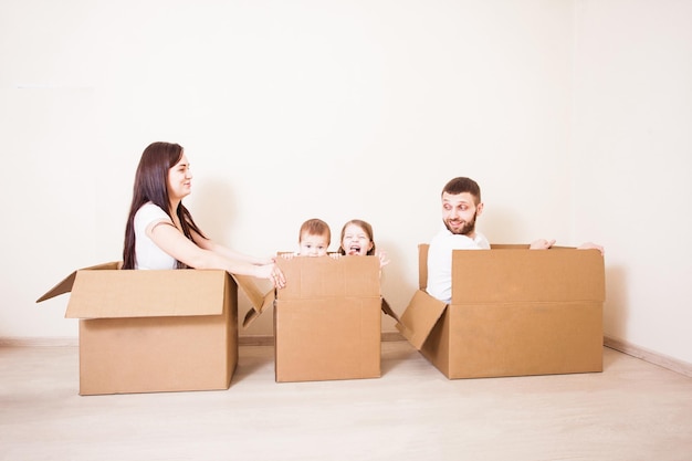 Familia feliz jugando en un tren de interior de cajas de cardborad