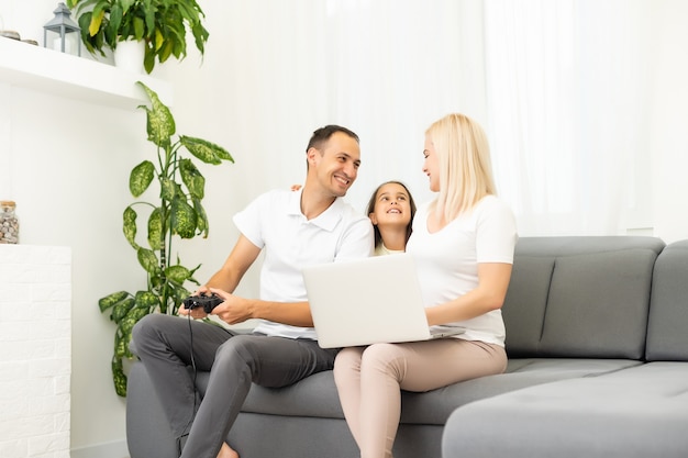 Familia feliz jugando videojuegos en casa y divirtiéndose juntos.