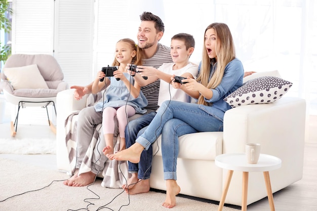 Familia feliz jugando videojuegos en casa