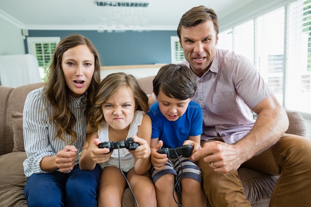 Familia feliz jugando videojuegos juntos en la sala de estar