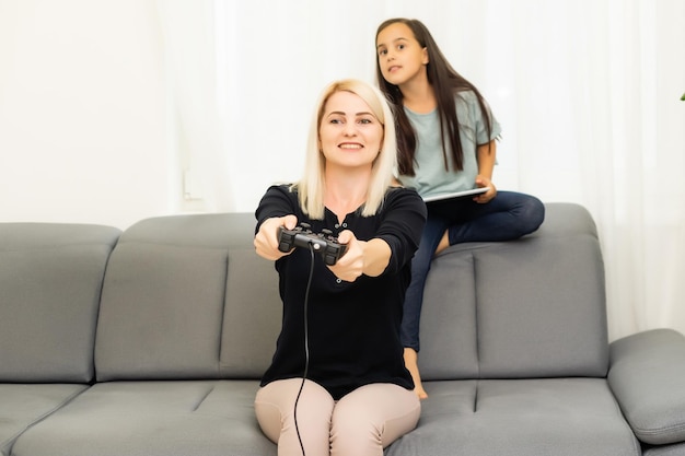 família feliz junta. mãe e sua filha jogando videogame. família relaxe.