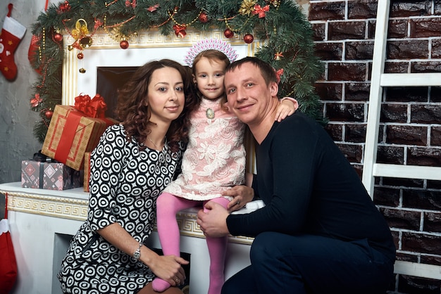 Foto família feliz junto à lareira para as férias de inverno. véspera de natal e véspera de ano novo.