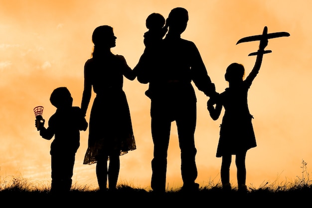 Familia feliz junto al mar en la silueta de la naturaleza