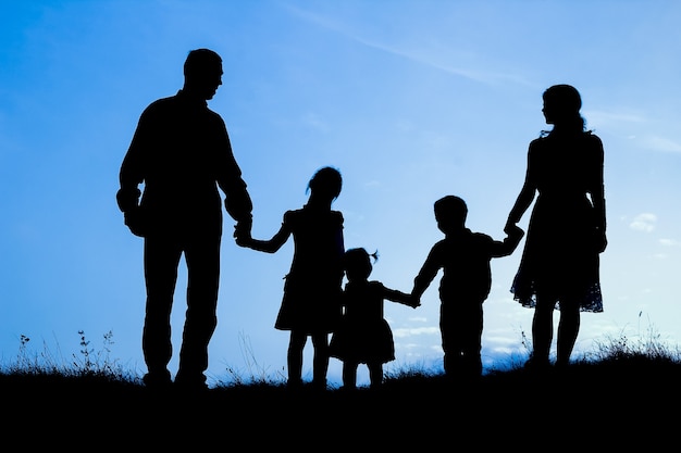 Familia feliz junto al mar en silueta de naturaleza