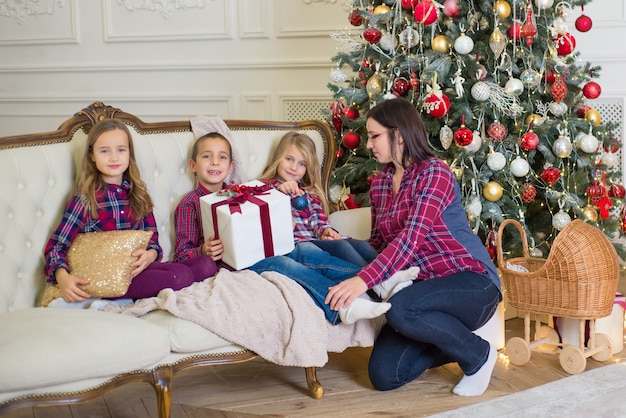 familia feliz junto cerca de un árbol de navidad en navidad en casa