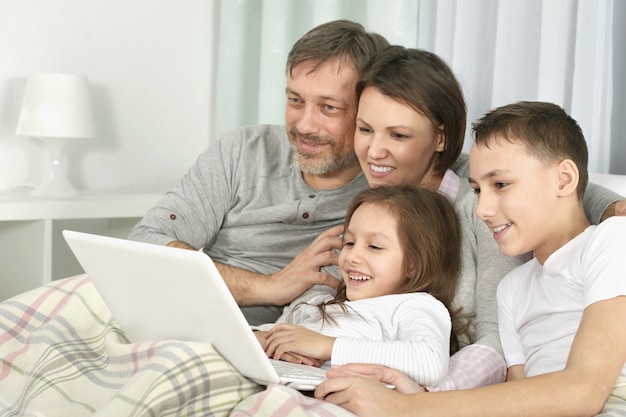 Familia feliz con laptop en una habitación