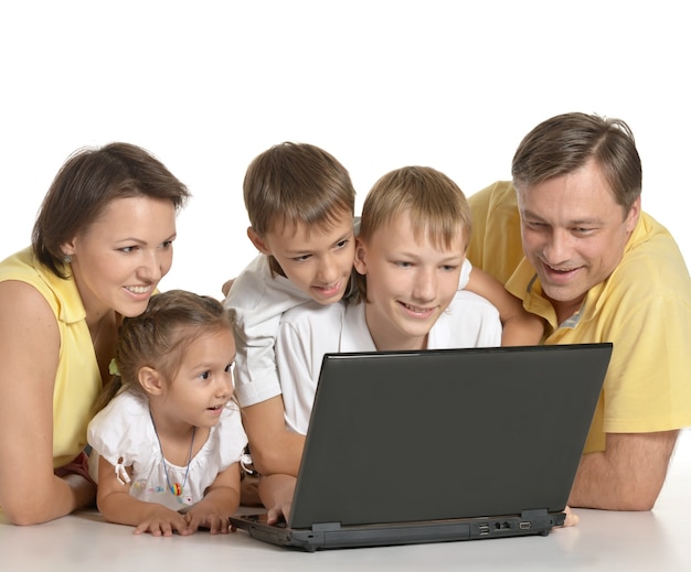 Familia feliz con laptop en el piso