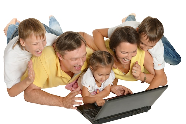 Foto familia feliz con laptop en el piso