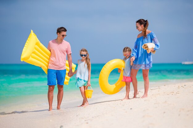 Família feliz linda na praia branca com colchões de ar