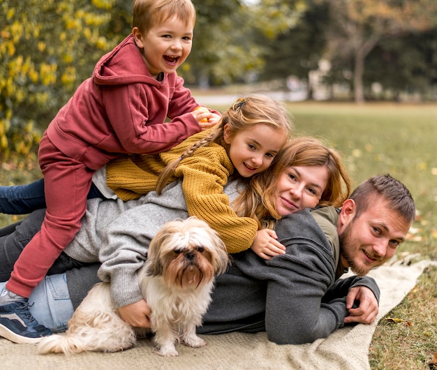 Foto familia feliz con lindo perro en la naturaleza