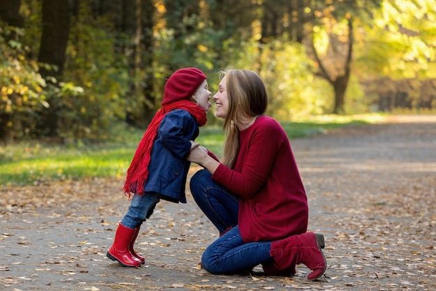 Familia feliz Madre e hija pasan tiempo en el parque de otoño Reír y jugar