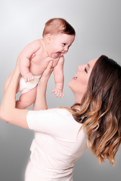 Una familia feliz. Madre con hija pequeña en sus brazos.