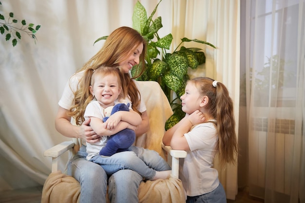 Familia feliz madre joven niñera relajarse divirtiéndose con los niños bonitos hijas en un