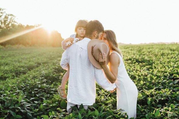 Familia feliz madre padre e hijo hija en la naturaleza al atardecer