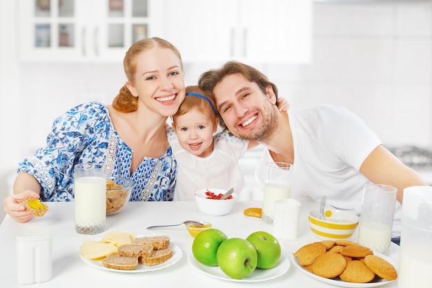 Familia feliz madre padre hijo desayunando