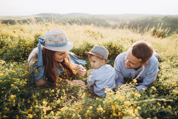 Familia feliz: madre, padre, hijos hijo en la naturaleza al atardecer