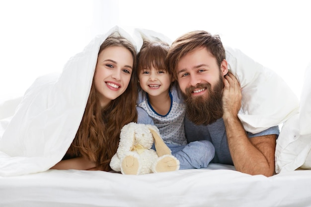 Familia feliz madre padre y padre hijo hija en la cama