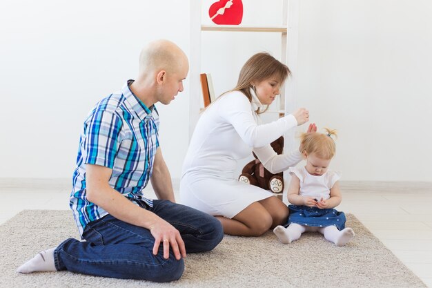 Familia feliz, madre, padre y su bebé juntos en la sala de estar en casa. Niños y niños pequeños