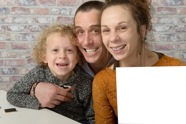 Foto familia feliz, la madre sosteniendo una hoja de papel blanco