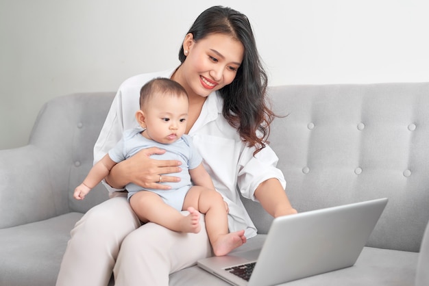 Família feliz mãe e bebê em casa usando laptop