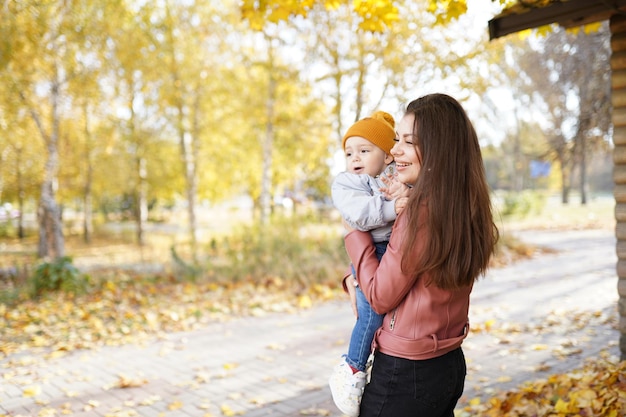 Família feliz, mãe e filho, garotinho caminhando no outono parque ao ar livre