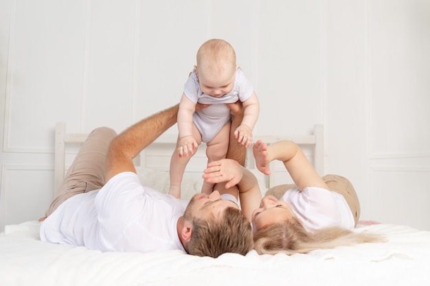 Família feliz, mãe, pai e bebê em casa se divertindo, bebê engatinhando em primeiro plano