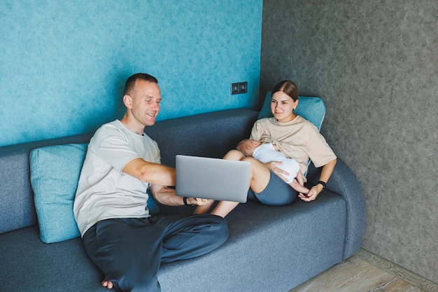 Família feliz mãe pai e filho bebê bonito se divertindo usando laptop em casa pais jovens e criança engraçada menino passando tempo de estilo de vida no computador sentado no sofá