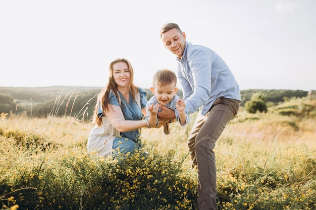 Foto família feliz: mãe, pai, filhos filho na natureza ao pôr do sol