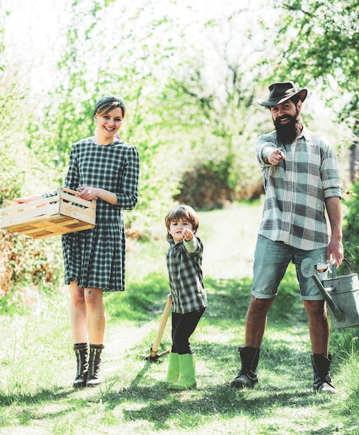 Família feliz mãe pai filhos filho no jardim da primavera jardinagem familiar no quintal