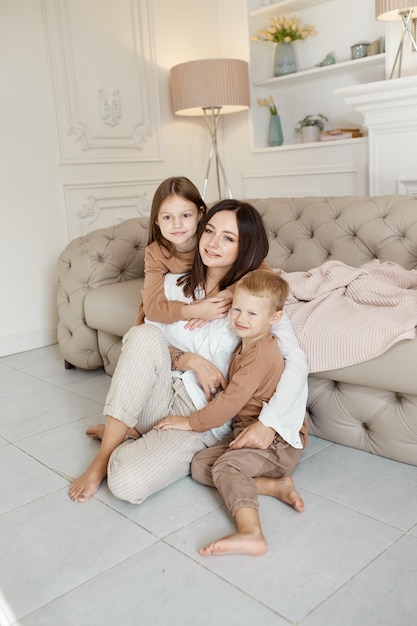 Familia feliz. Mamá abraza a hijo e hija