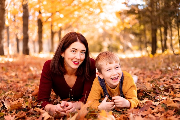 Familia feliz, mamá y bebé juegan al aire libre en la naturaleza en el parque de otoño Un niño y su madre en el parque de otoño Entretenimiento de otoño para niños