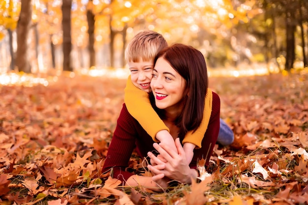 Familia feliz, mamá y bebé juegan al aire libre en la naturaleza en el parque de otoño Un niño y su madre en el parque de otoño Entretenimiento de otoño para niños