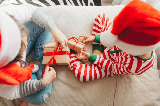 Familia feliz, mamá e hijo, abrazándose y dando regalos en la cama en la mañana de Navidad. Navidad.