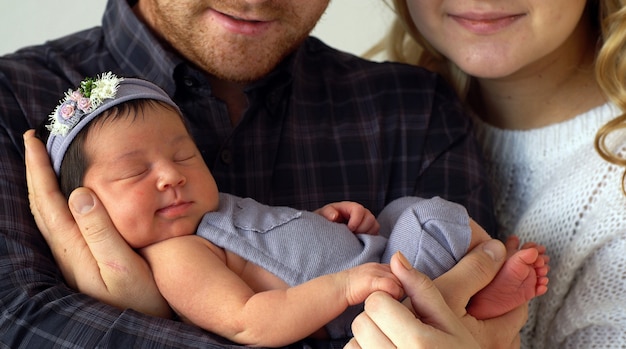 Foto família feliz mantém filha recém-nascida