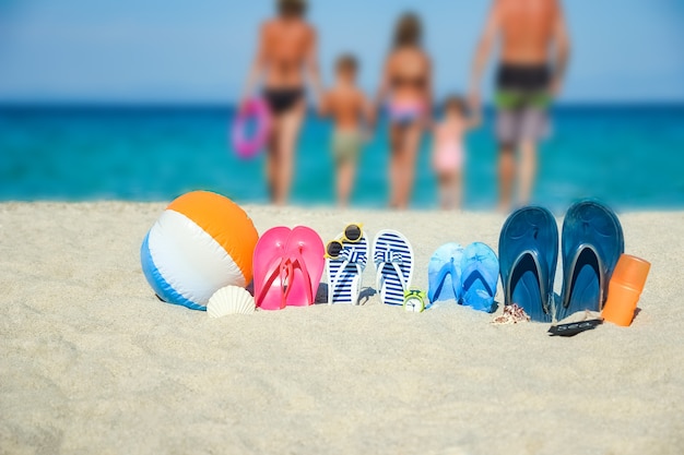 Familia feliz en el mar con zapatillas