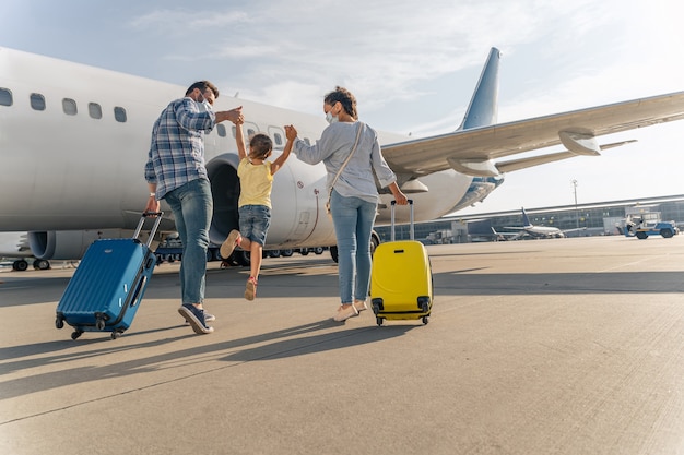 Família feliz mascarada curtindo a viagem