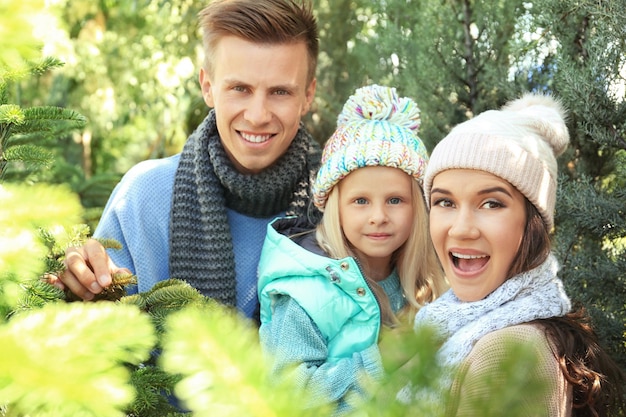 Familia feliz en el mercado de árboles de Navidad